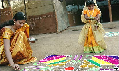 Joven y niña haciendo una pintura tradicional en India