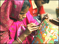 Joven india pintando un pote de cerámica